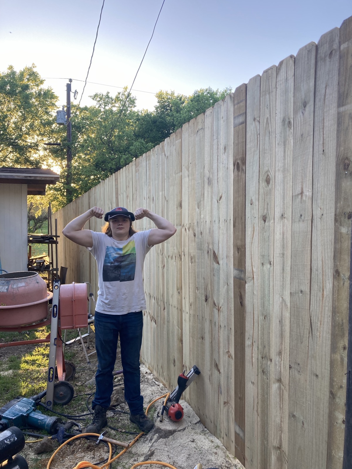 Atro, founder of Sweatystoves, standing by a fence he built